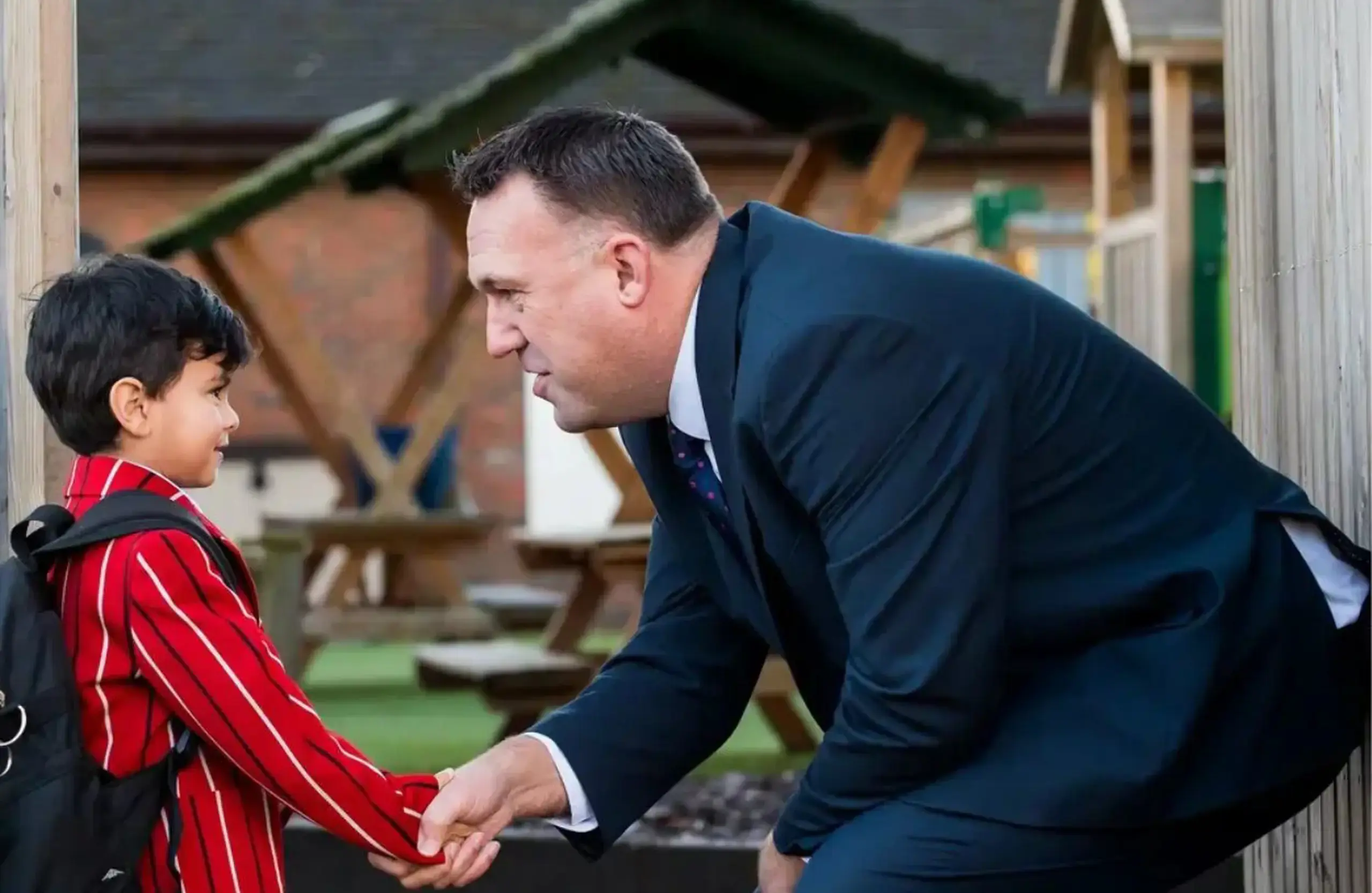 Head teacher shaking hands with student