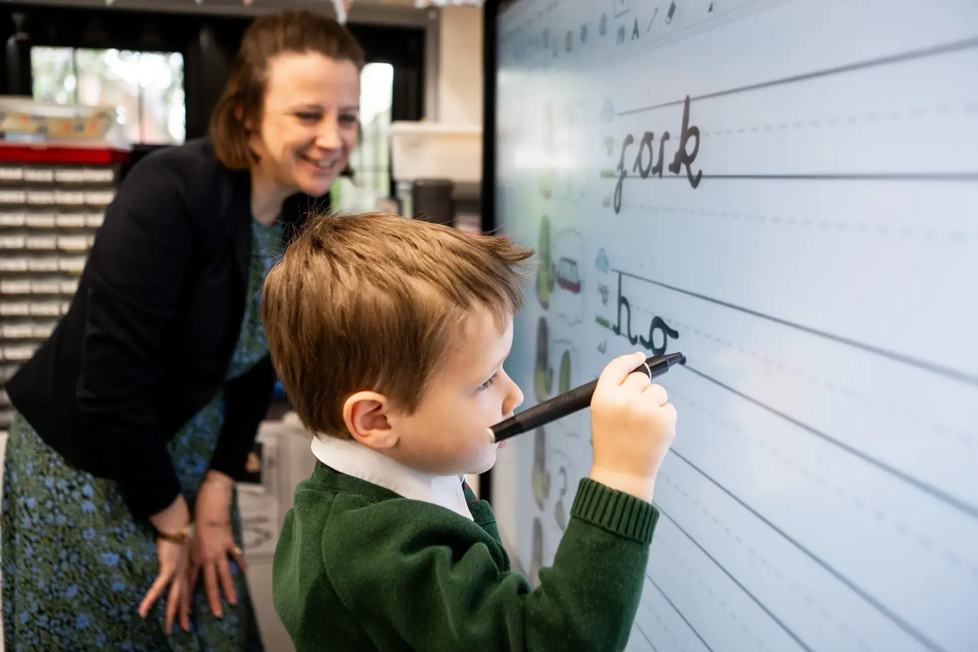 Student writing on interactive whiteboard