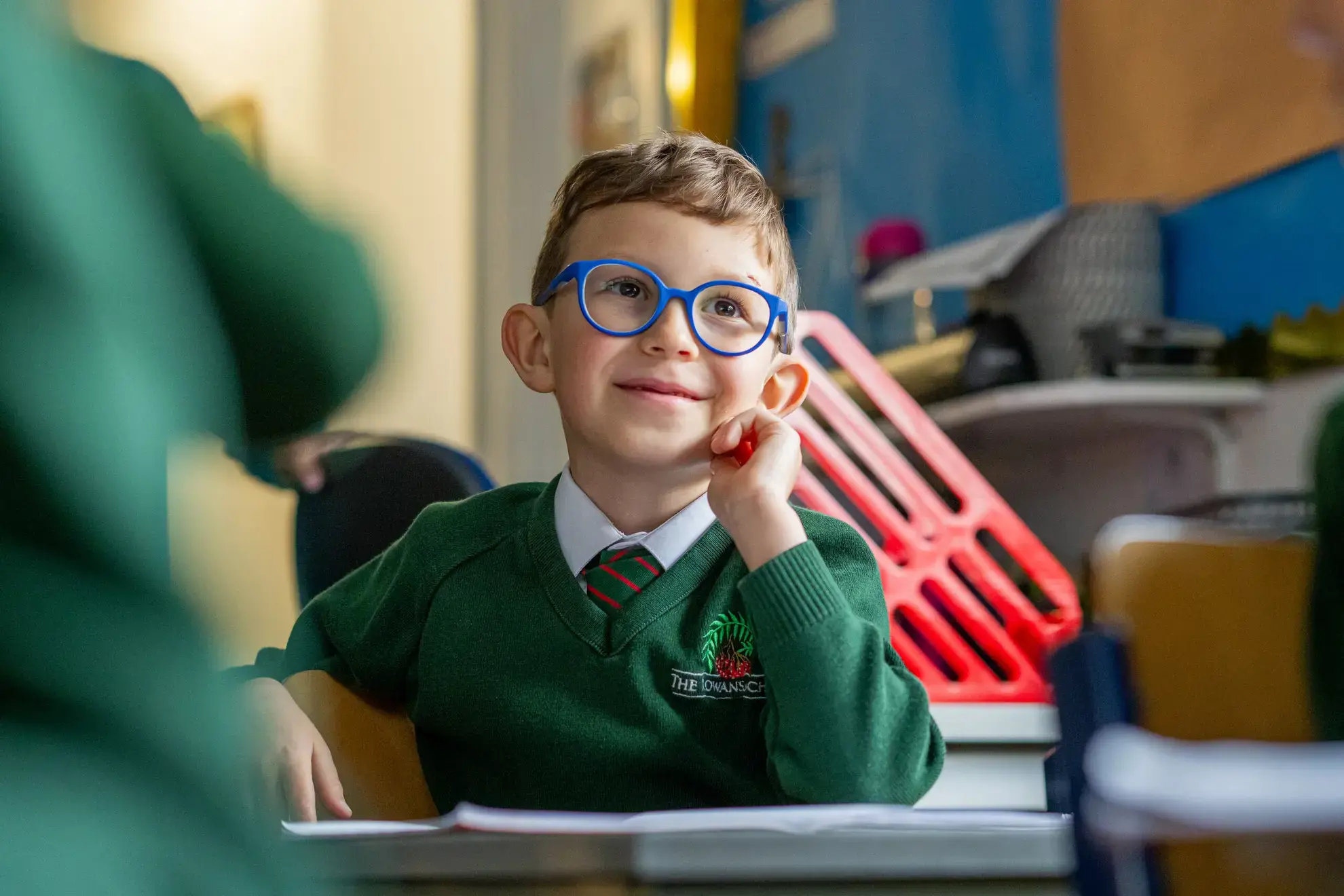 Student in blue glasses paying attention in lesson