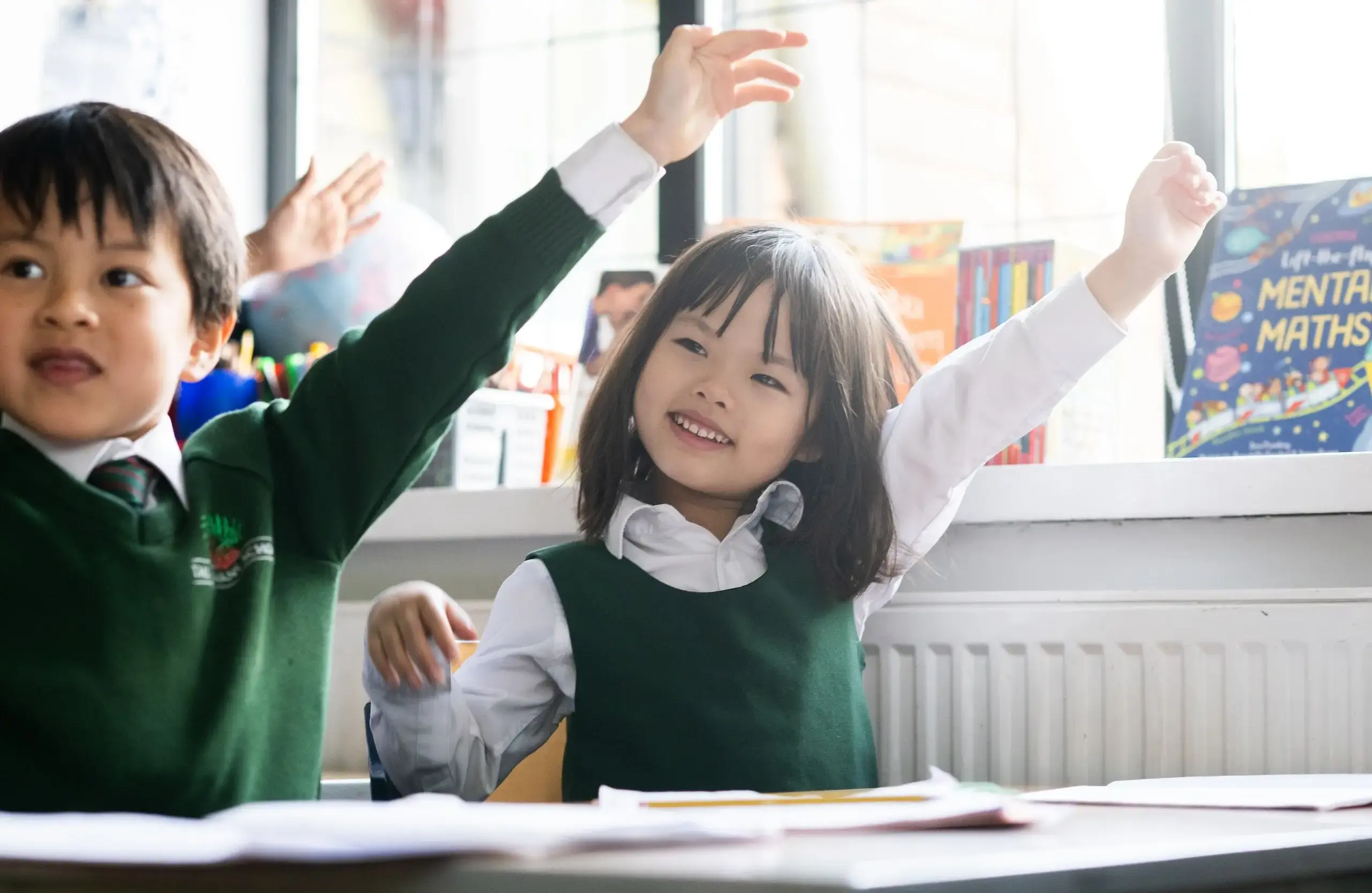 Students putting up their hands in a lesson