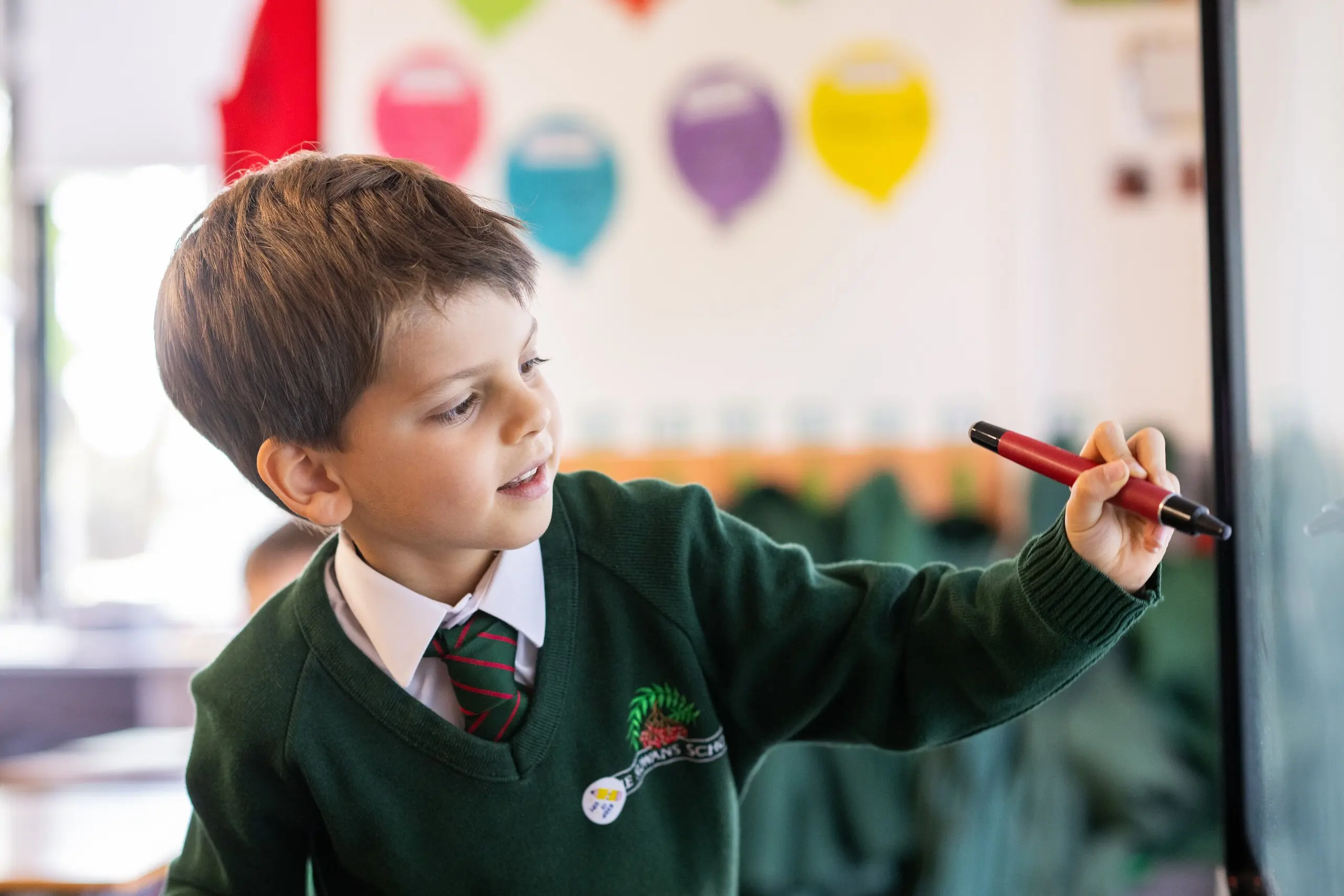 Student writing on interactive whiteboard