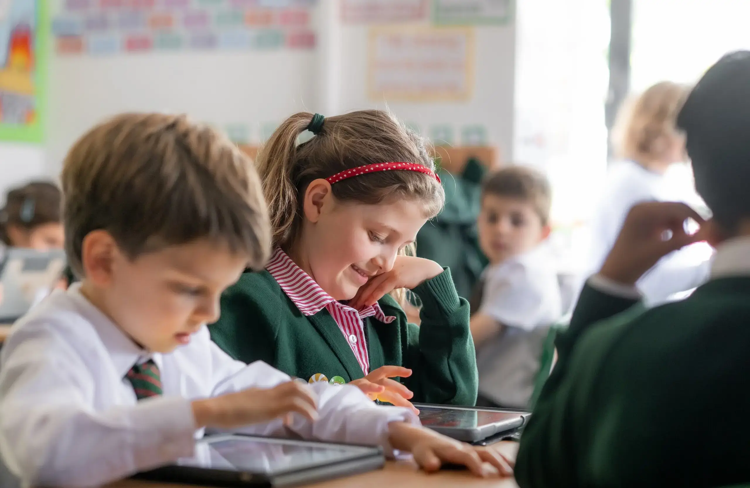 Student in a packed classroom smiling down at their schoolwork