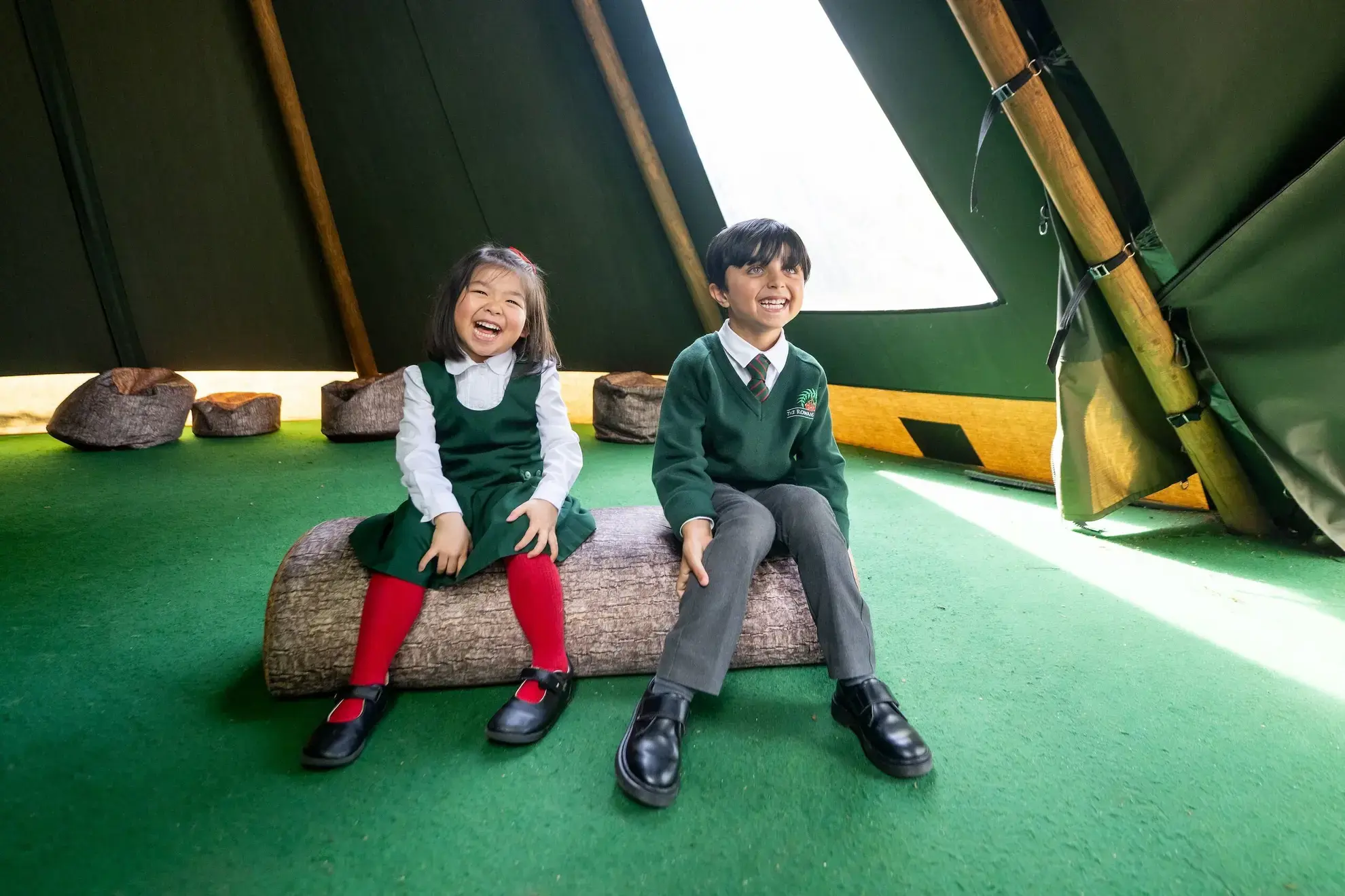 Two students laughing in a tipi