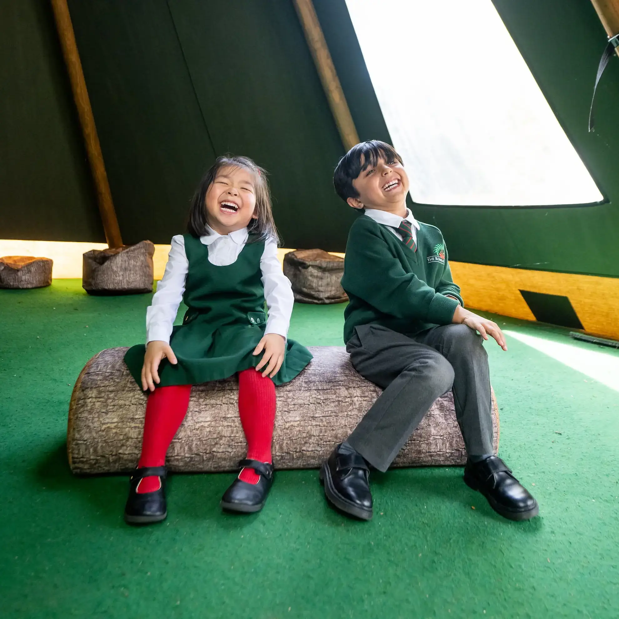 Two students laughing in a tipi