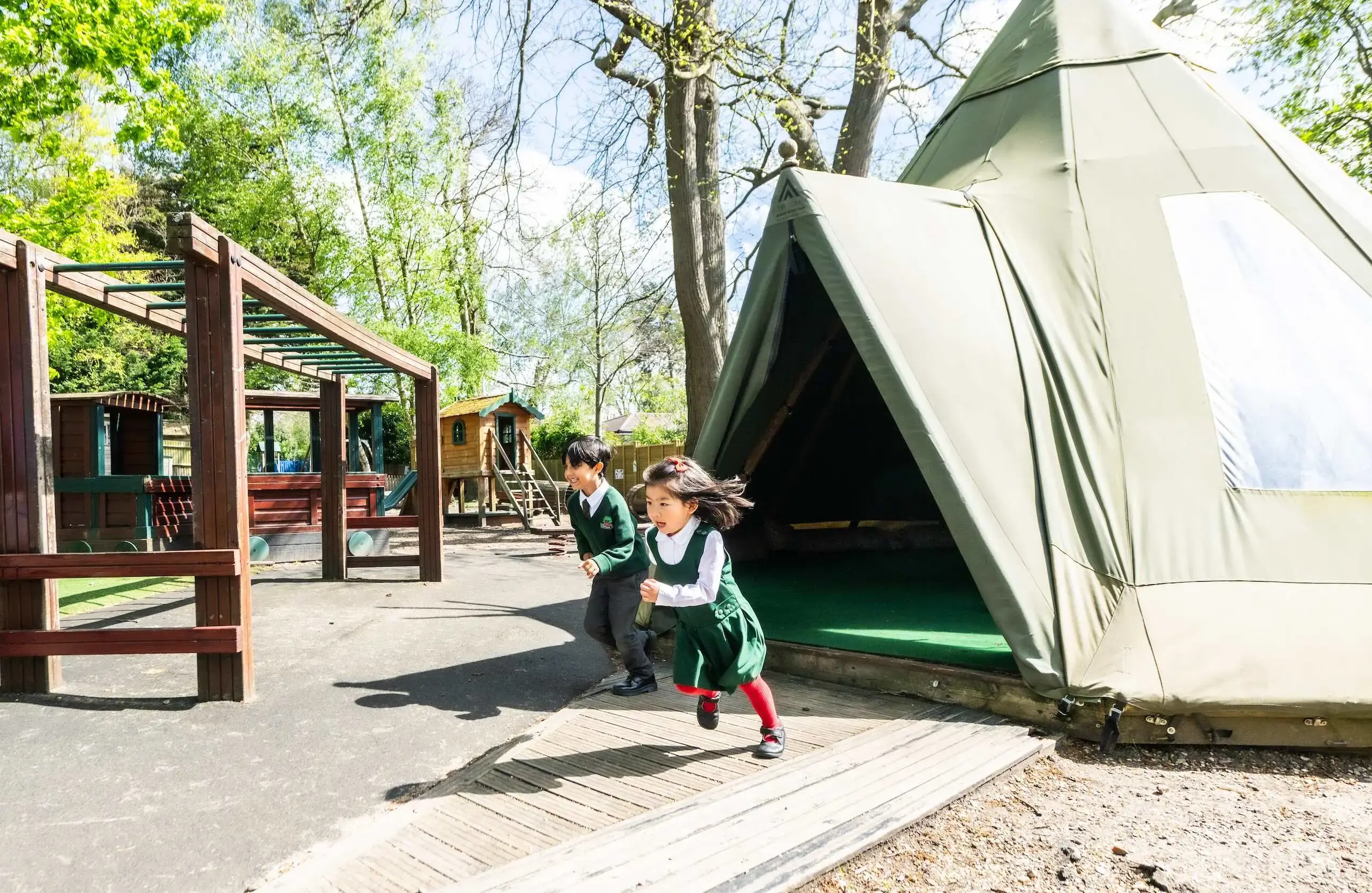 Two students running out of a tipi
