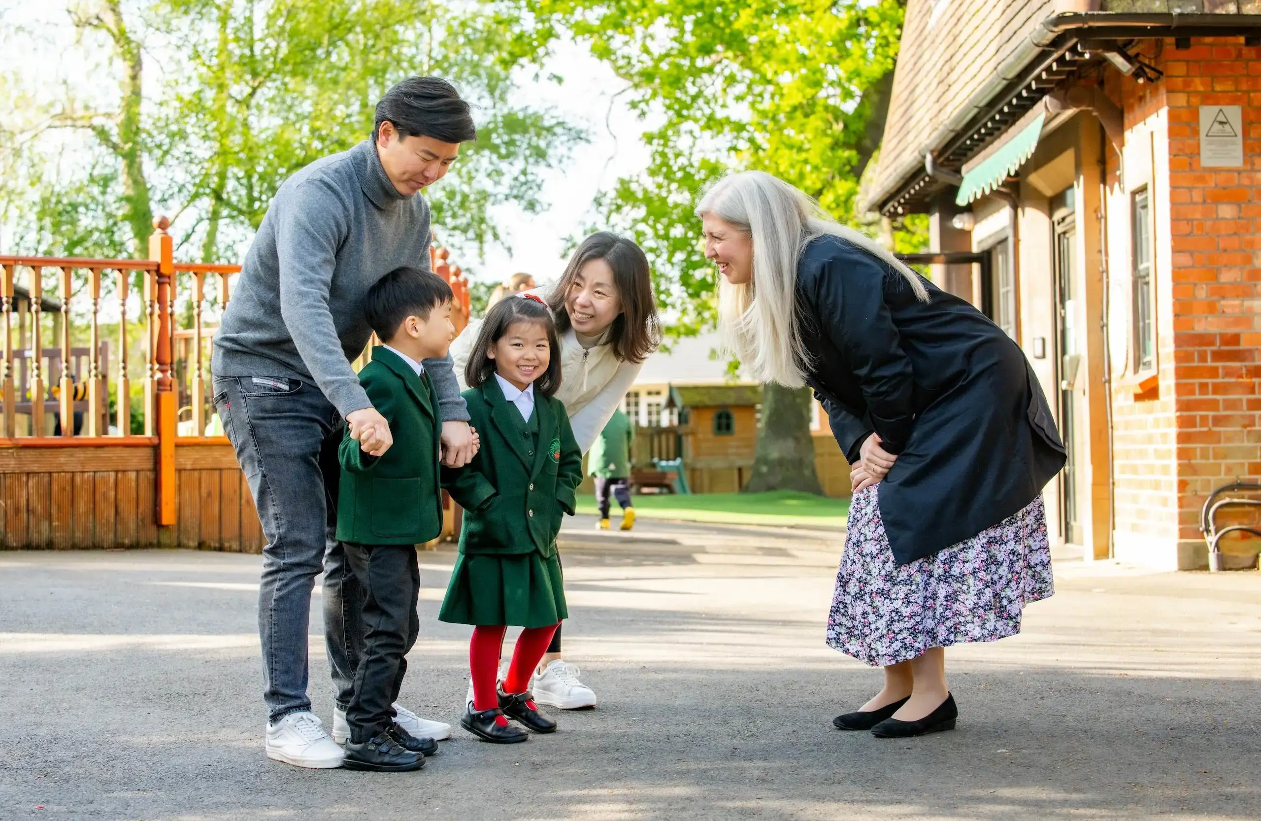 Head teacher having a cheerful conversation with two parents and their two children