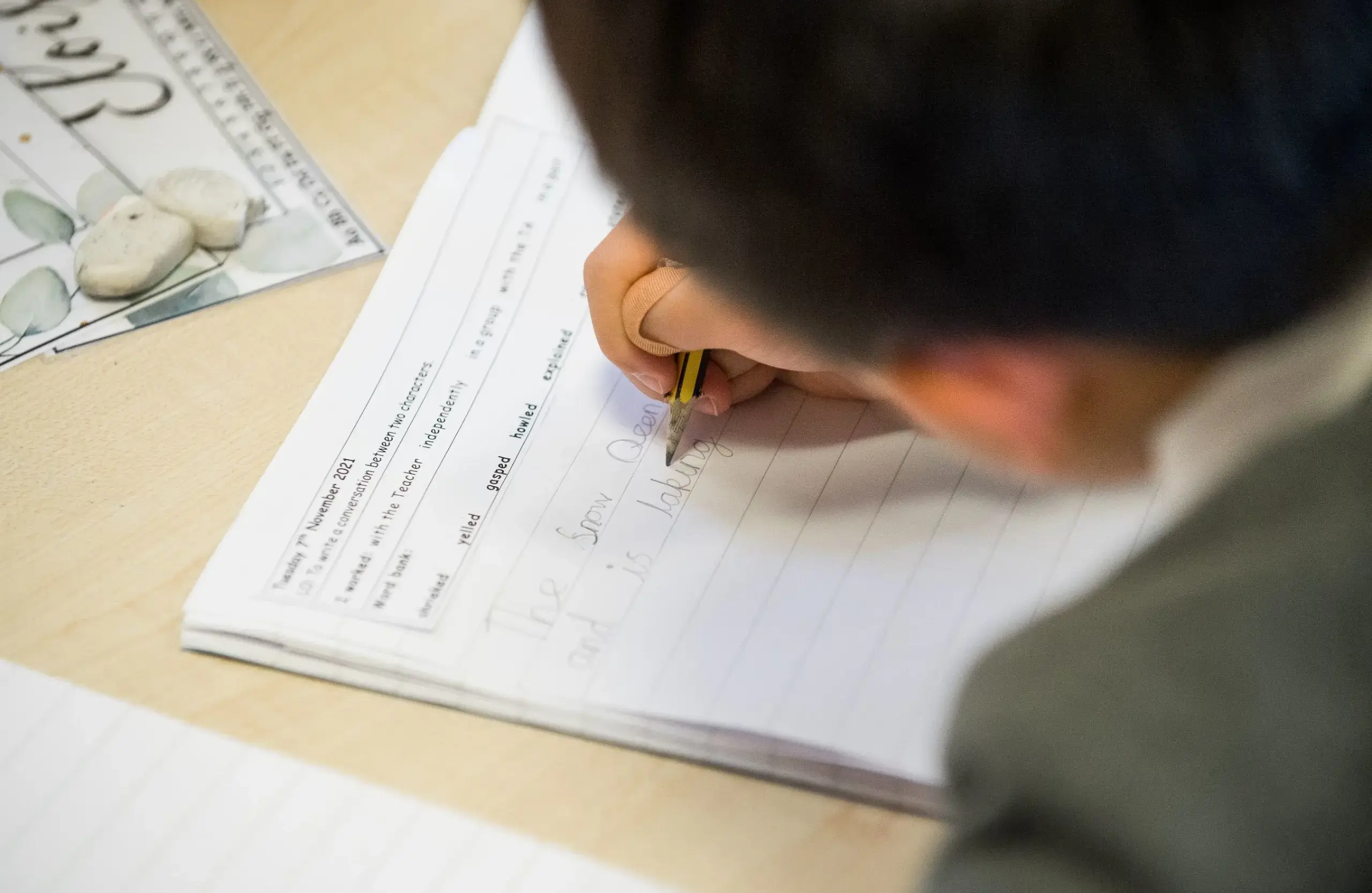 Srudent filling in answers on paper for classwork