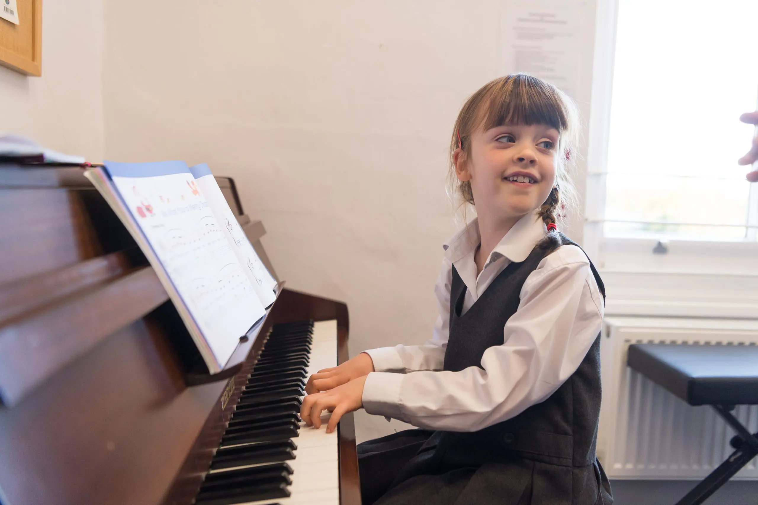 Student playing the piano and smiling