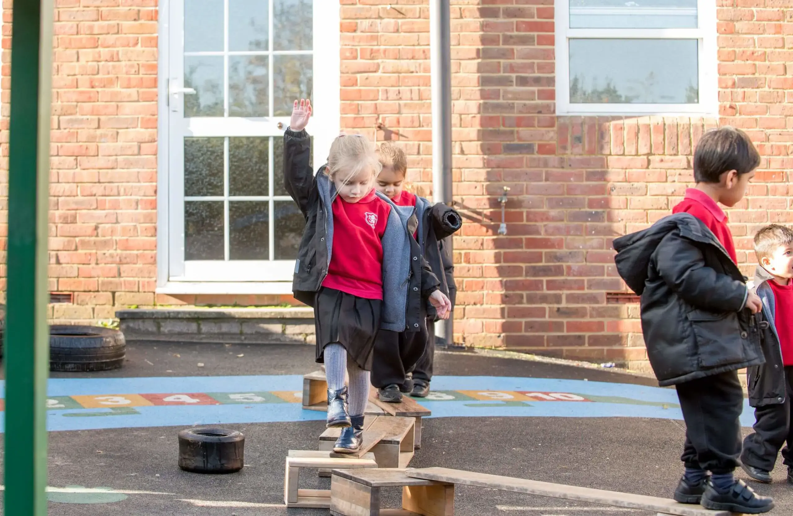 Shrewsbury House Pre-Prep students playing on makeshift balance beams in the playground