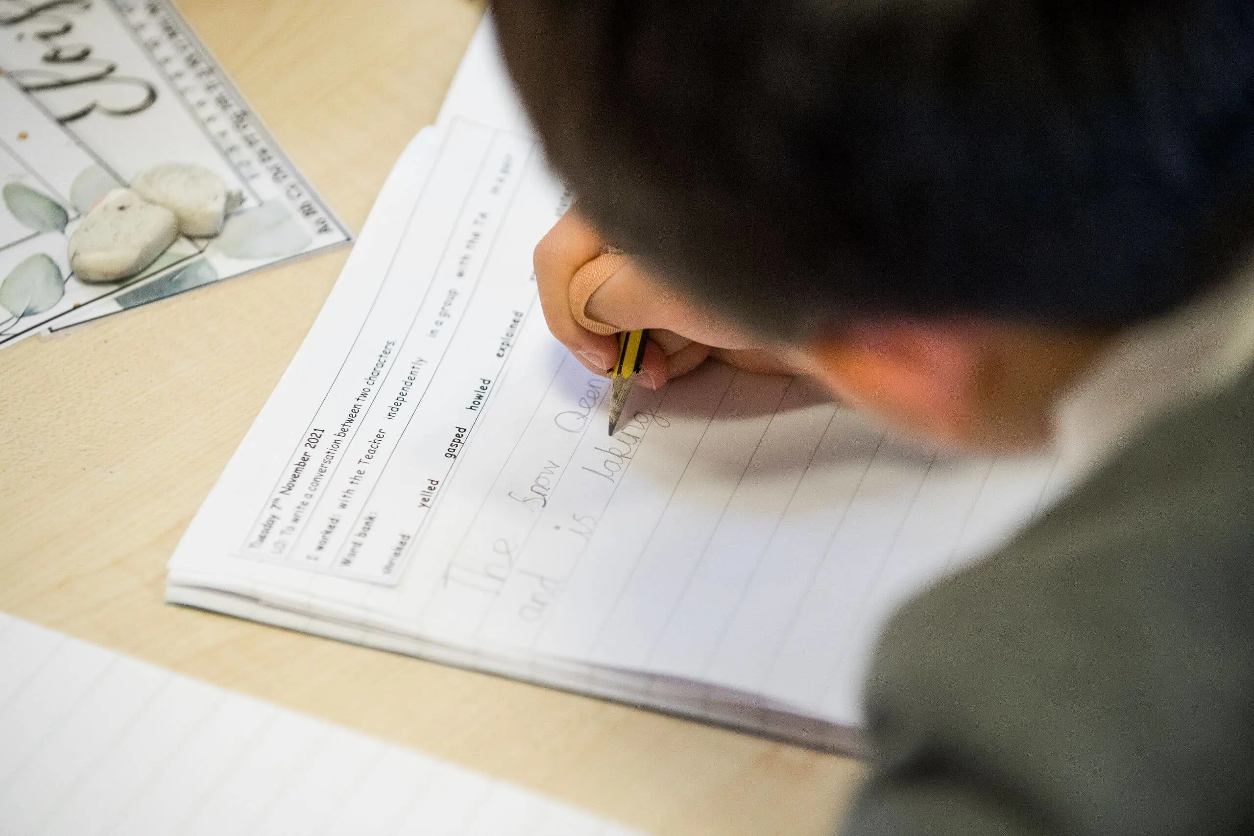 Shrewsbury House Pre-Prep Student writing in a workbook.
