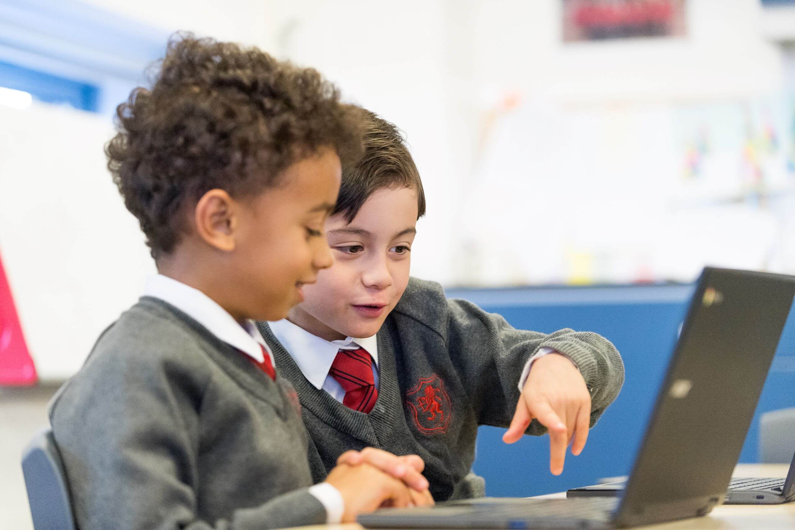 Shrewsbury House Pre-Prep Students helping each other with work on laptops