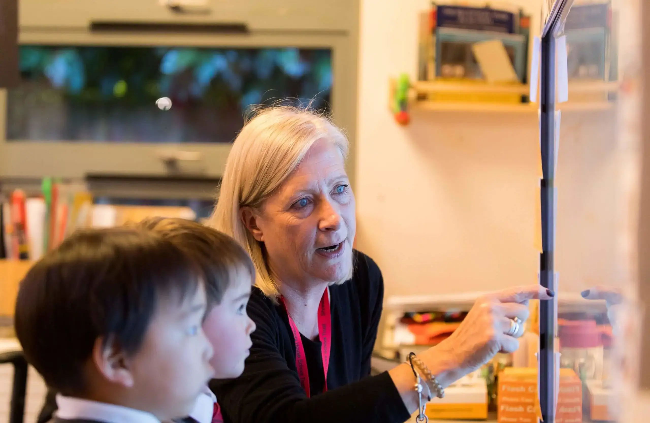 Teacher helping students at interactive whiteboard