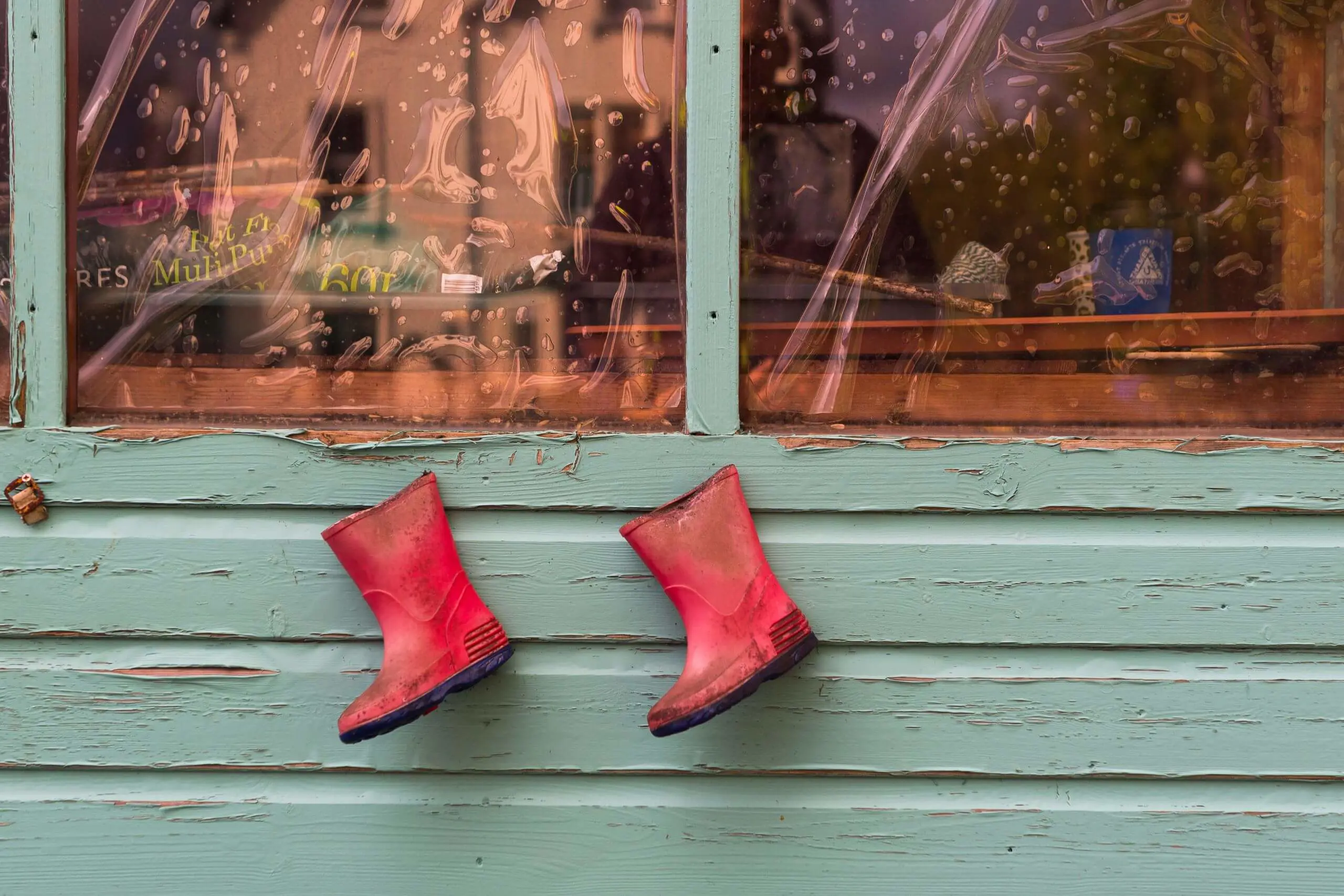 Shrewsbury House Pre-Prep School red wellington boots used as flower pots pinned to the side of a shed