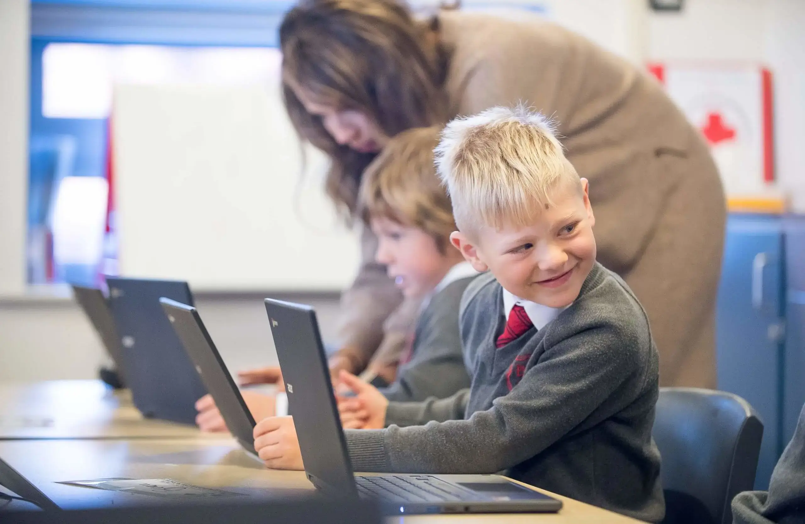 Shrewsbury House Pre-Prep teacher and students working with laptops