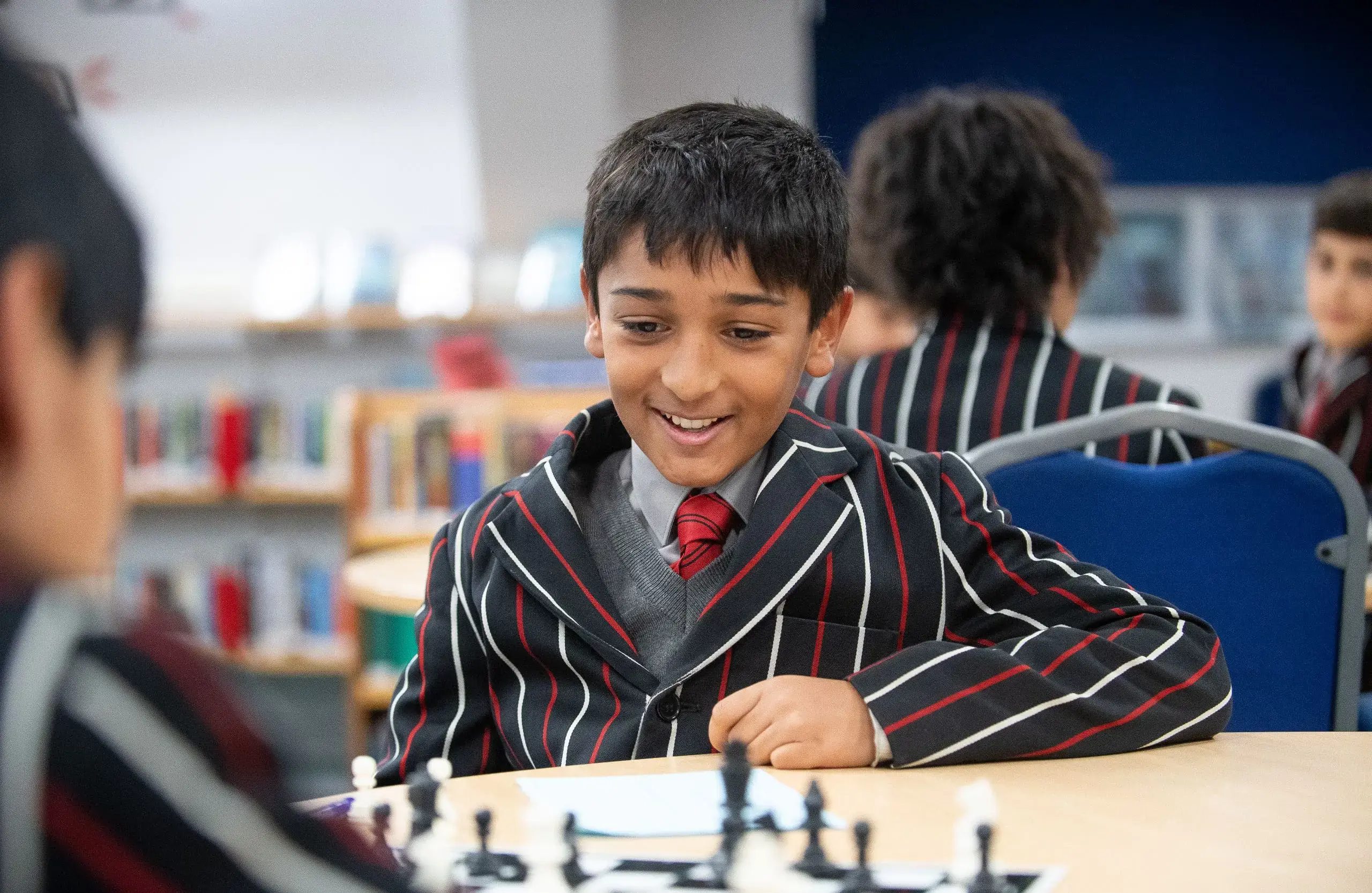 Boy playing chess, smiling