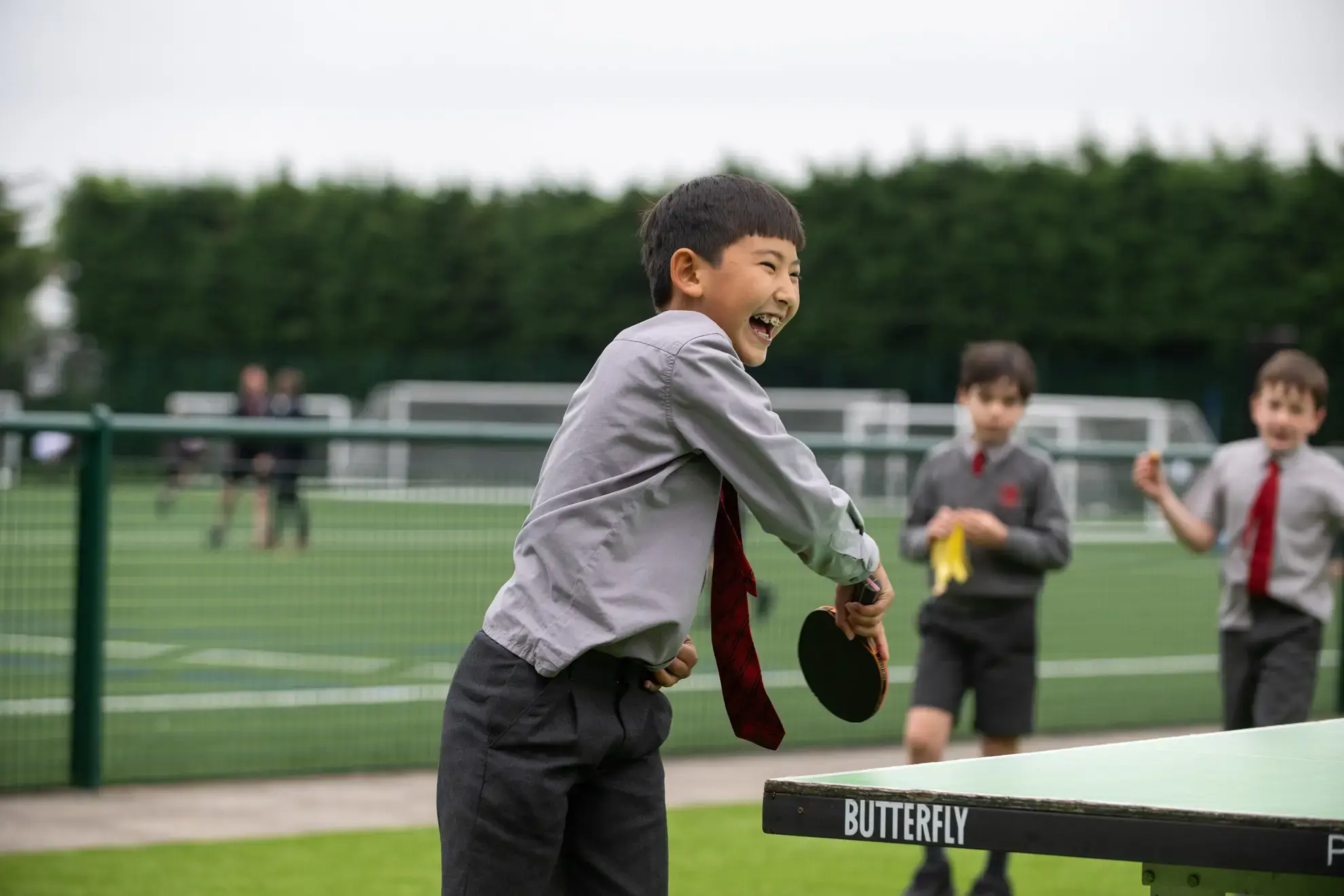 Student playing table tennis outdoors