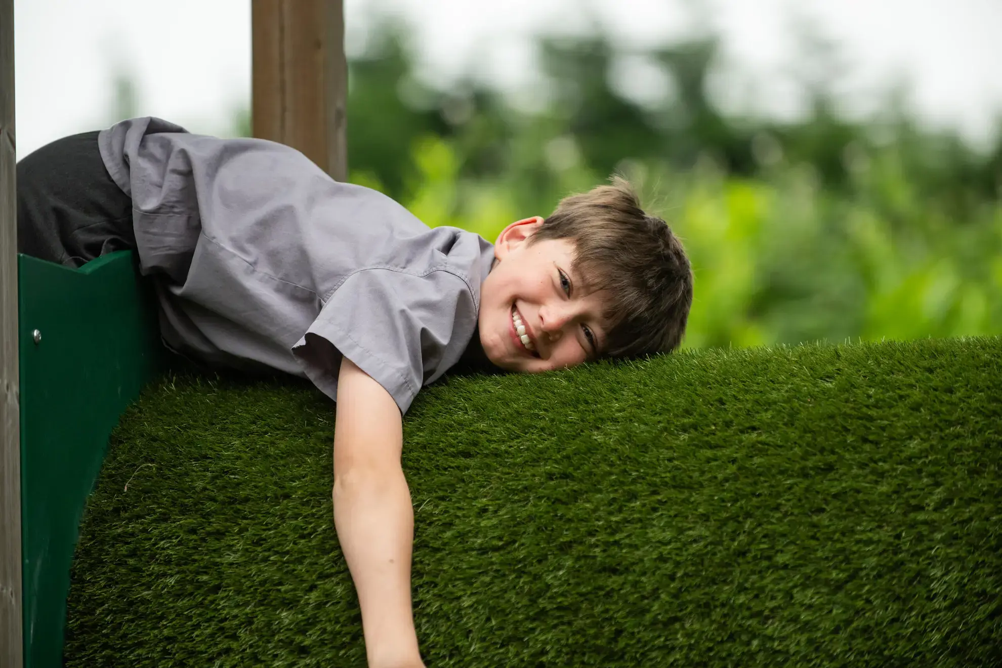 Student lying on hedge, smiling