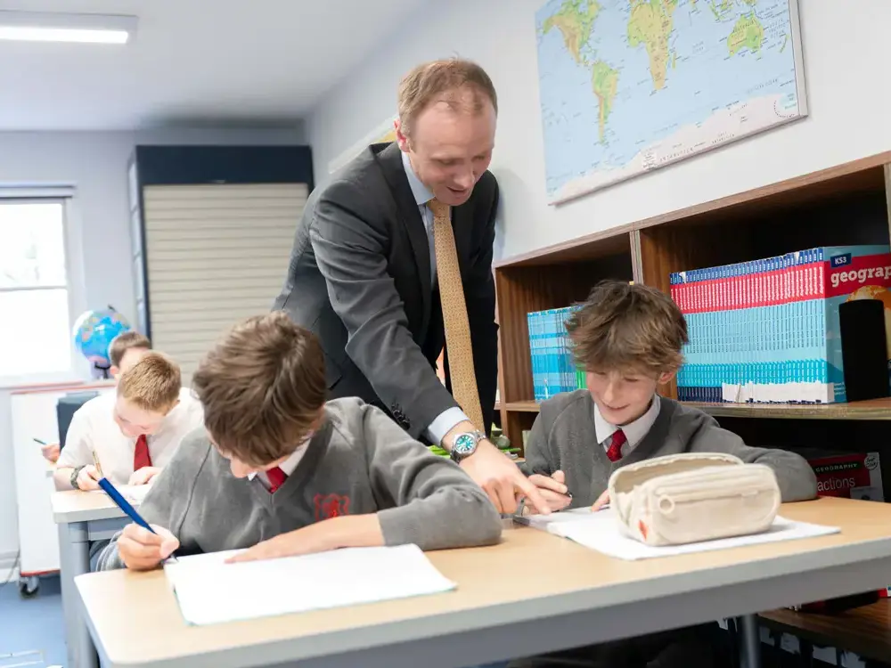 Shrewsbury House Prep Geography teacher helping pupils with classwork.