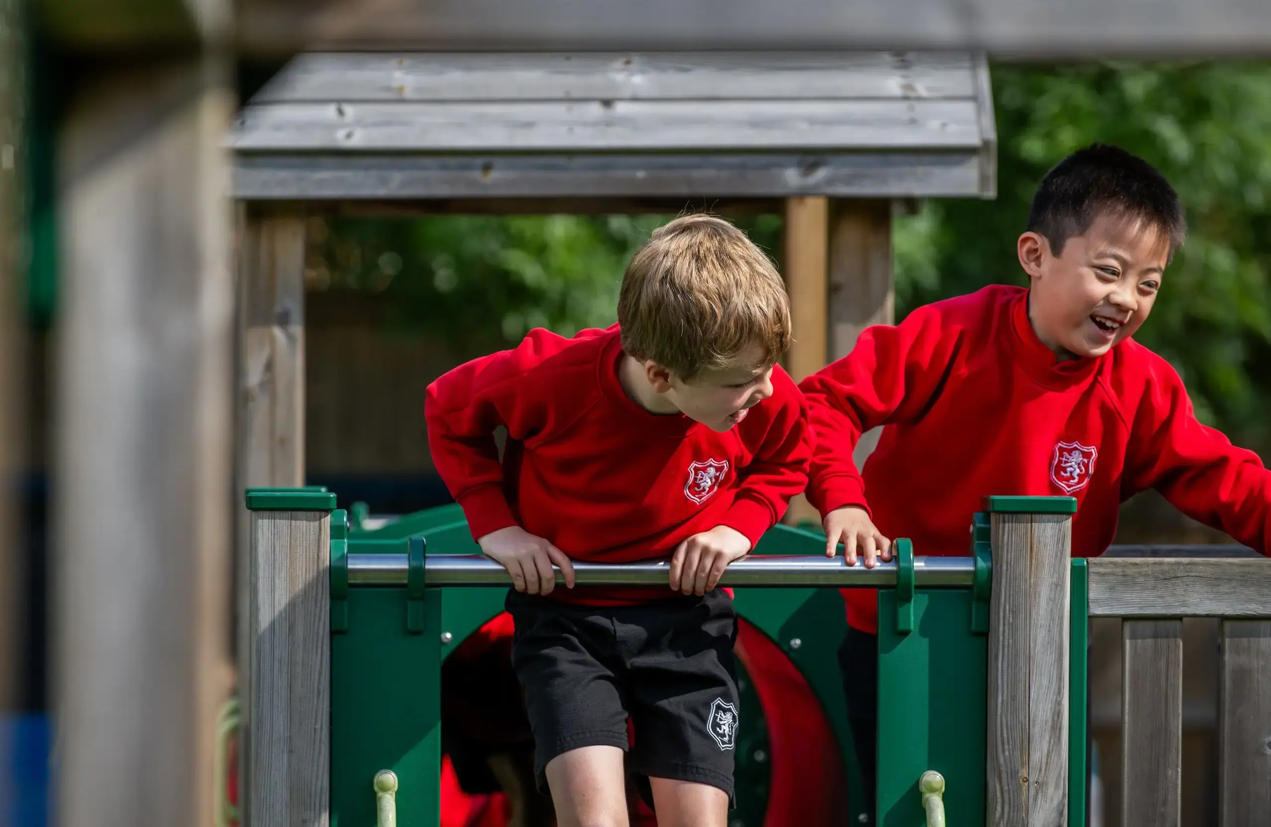 Two students laughing on playground equipment