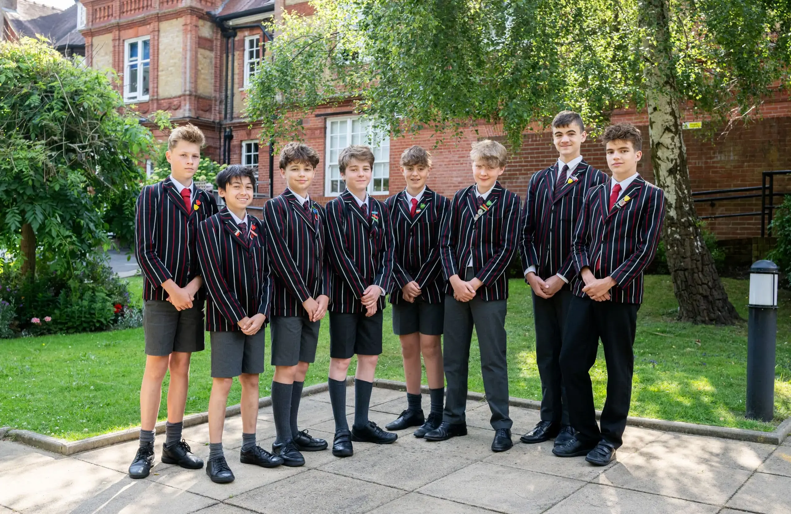 Year 7 and 8 boys in uniform posing for a school group photo outside Shrewsbury House School