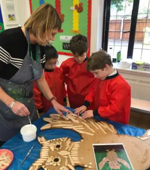 teacher with students makes owl art project