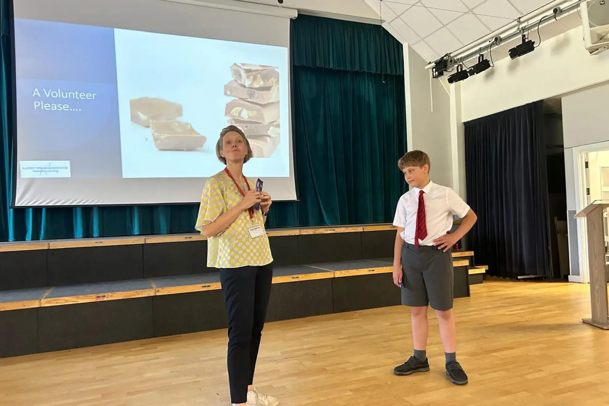 Teacher with a student volunteer beside her during a presentation