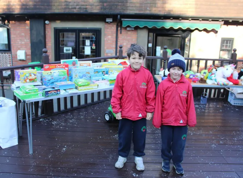 Two students in front of toy swap tables